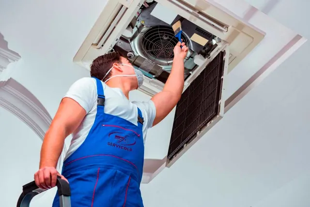 Técnico revisando un sistema de aire acondicionado de techo